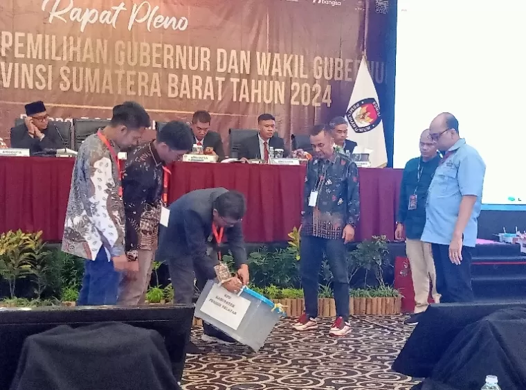 Proses buka kotak yang dilakukan KPU Pessel sebelum pembaca hasil rekap tingkat kabupaten di rapat pleno penetapan hasil perolehan suara gubernur dan wakil gubernur oleh KPU Sumbar di Padang, Sabtu (7/12/2024). (dok : arunala.com)