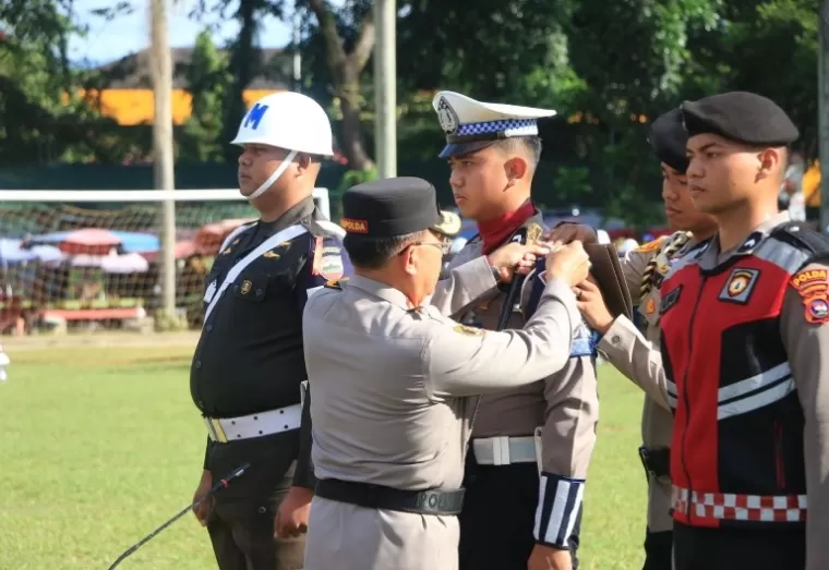 Kapolda Sumbar Irjen Pol Suharyono pasang pita pada personel pada apel pasukan pengamanan nataru di lapangan Imam Bonjol Padang, Jumat (20/12/2024). IST