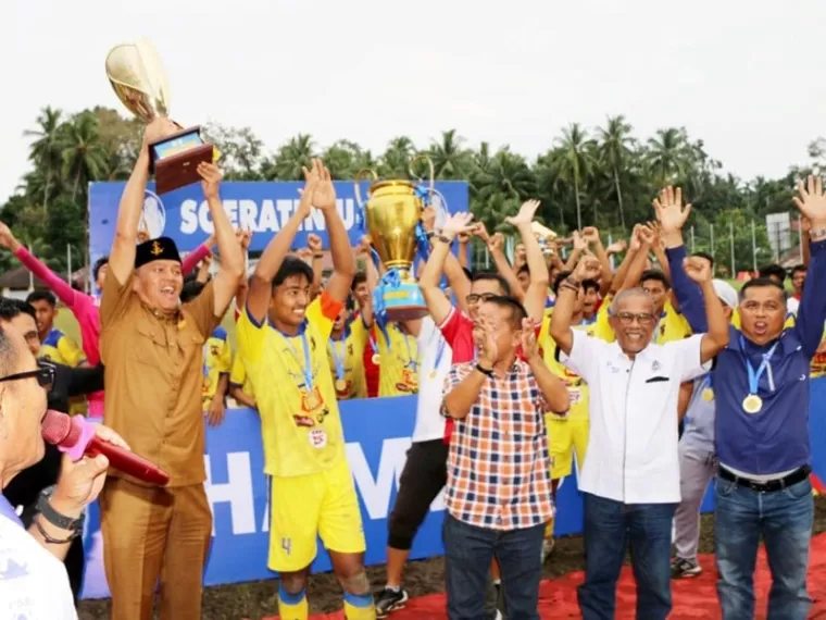 Pj Wali Kota Pariaman, Roberia antusias mengangkat piala Soeratin U-17 setelah tim Persikota Pariaman tumbangkan tim Josal FC 2-1 di laga final, Selasa sore (3/12/2024). IST