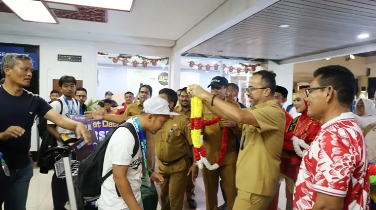 Kepala Dispora Sumbar, Maifrizon kalungkan bunga kepada pemain Persikopa Pariaman disaksikan Pj Wali Kota sekaligus Ketum Persikopa Roberian di BIM, Senin sore (23/12/2024). IST