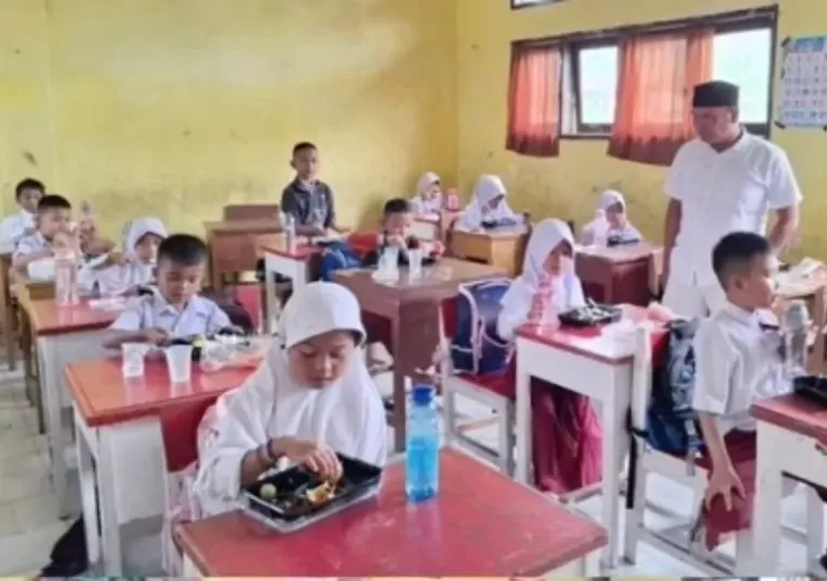 Para siswa di SDN 21 Jalan Kereta Api, Kota Pariaman menikmati program Makan Bergizi Gratis (MBG) yang mereka makan saat jam istirahat sekolah, Selasa (7/1/2025). IST