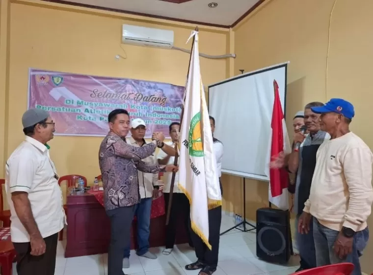 Ketua umum (Ketum) PASI Kota Padang terpilih, Irwandi terima pataka dari Plt Ketum AKBP Indra Jonedi dalam muskot PASI Kota Padang, Jumat sore (7/2/2025). IST