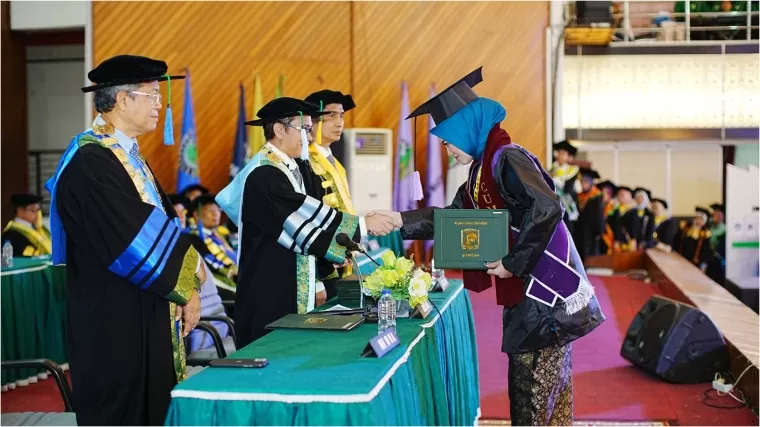 Rektor Unand Efa Yonnedi, Ph.D menyerahkan ijazah secara simbolis kepada lulusan terbaik saat Wisuda I Tahun 2025 di Auditorium Unand, Sabtu (8/2/2025). Humas Unand