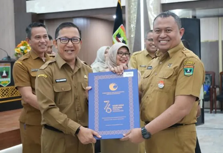 Pj Sekko Pariaman, Mursalim, saat menerima penghargaan dari Kementerian HAM yang diserahkan Pj Sekprov Sumbar, Yozarwardi di Padang, Selasa (25/2/2025). IST