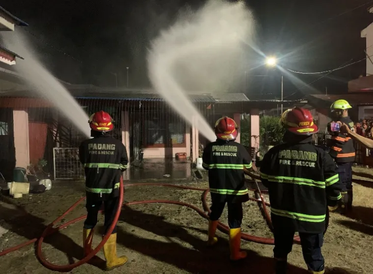 Beberapa petugas Damkar Padang lakukan pemadaman api pada rumah warga yang terbakar, Minggu malam (16/3/2025). IST
