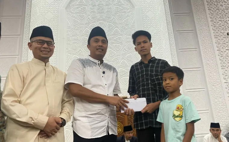 Wagub Sumbar, Vasko Ruseimy serahkan bantuan beasiswa kepada salah seorang pelajar saat safari Ramadan di salah satu masjid di Kota Bukittinggi, Minggu (9/3/2025). IST