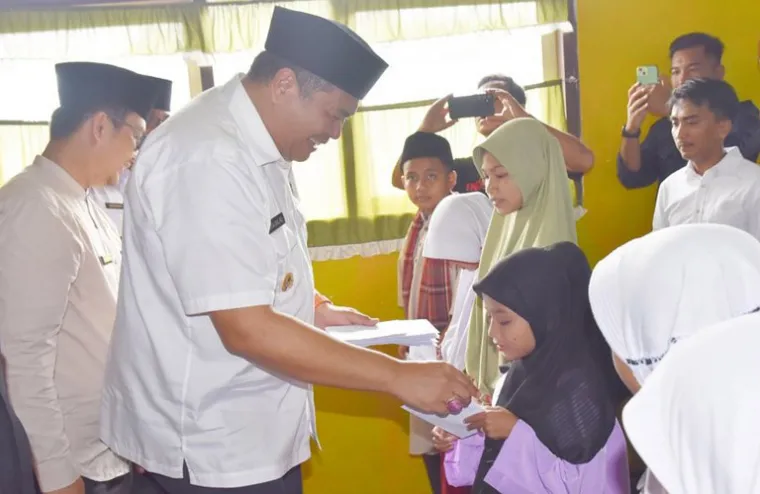 Wali Kota Pariaman, Yota Balad serahkan infaq mingguan PTK SD Kecamatan Pariaman Utara kepada salah seorang murid SD,  Rabu (12/3/2025). IST