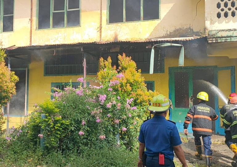 Petugas Damka Kota Padang melakukan pemadaman api yang membakar salah satu ruang kelas di bangunan bekas SMP Nasional di Kelurahan Rimbo Kaluang,  Senin (26/5/2025). (dok : damkar kota padang)