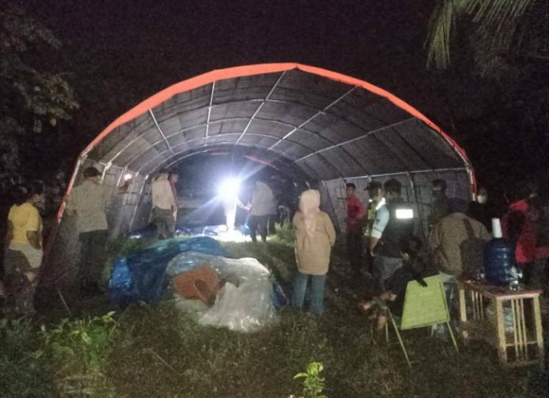 BPBD Kota Padang melakukan pemasangan tenda antisipasi meluasnya kebakaran ke pemukiman masyarakat sekitar pabrik, Minggu malam (18/5/2025). (dok : bpbd padang)