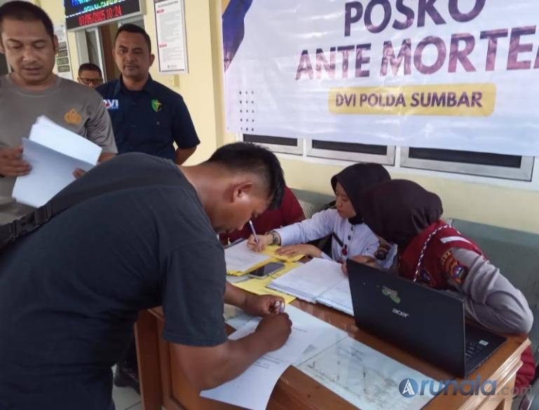 Terlihat salah satu pihak keluarga korban meninggal kecelakaan bus ALS tanda tangani dokumen penyerahan jenazah pada pihak Rumkit Bhayangkara Polda Sumbar, Rabu siang (7/5/2025). (dok : arunala.com)