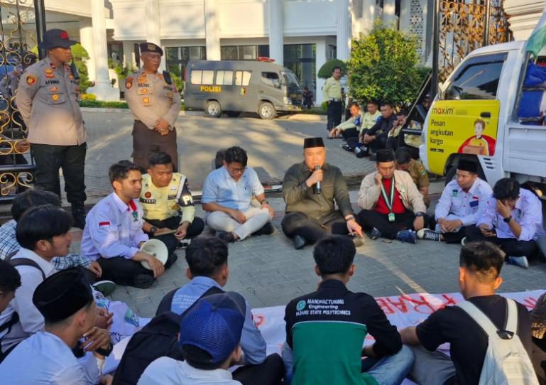 Terlihat Wakil Ketua DPRD Sumbar, Nanda Satria duduk bersama para mahasiswa sambil berikan penjelasan atas aksi yang digelar mahasiswa ini di halaman gedung DPRD Sumbar, Selasa (29/4/2025). IST