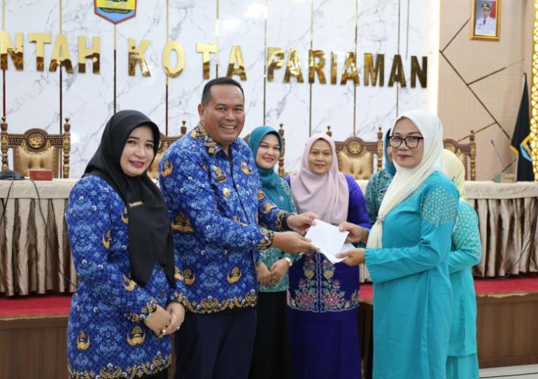 Salah seorang pengurus Dasawisma menerima uang pengganti yang diserahkan Wali Kota Pariaman, Yota Balad, Selasa (17/6/2025). IST