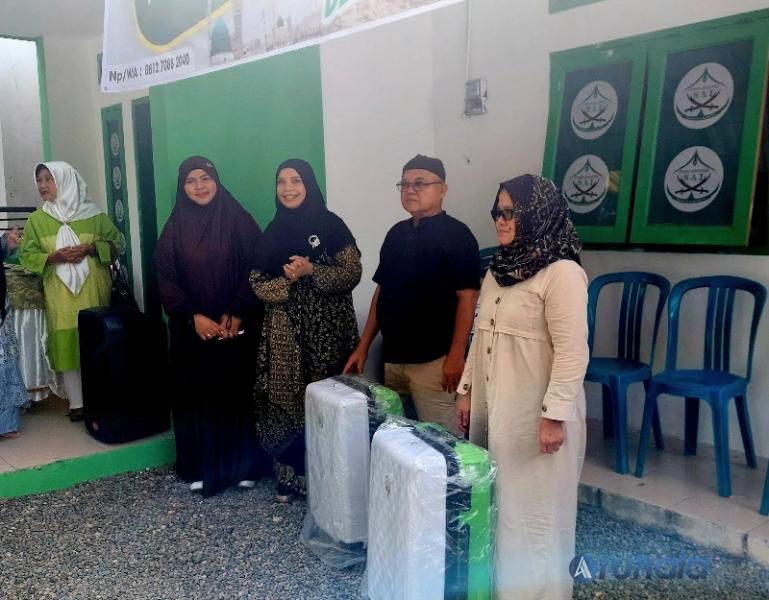 Owner PT SAI, Umi Syarifah serahkan secara simbolis koper keberangkatan kepada dua calon jamaah umroh PT SAI yang akan berangkat Juli ini, Minggu (29/6/2025). (arunala.com)