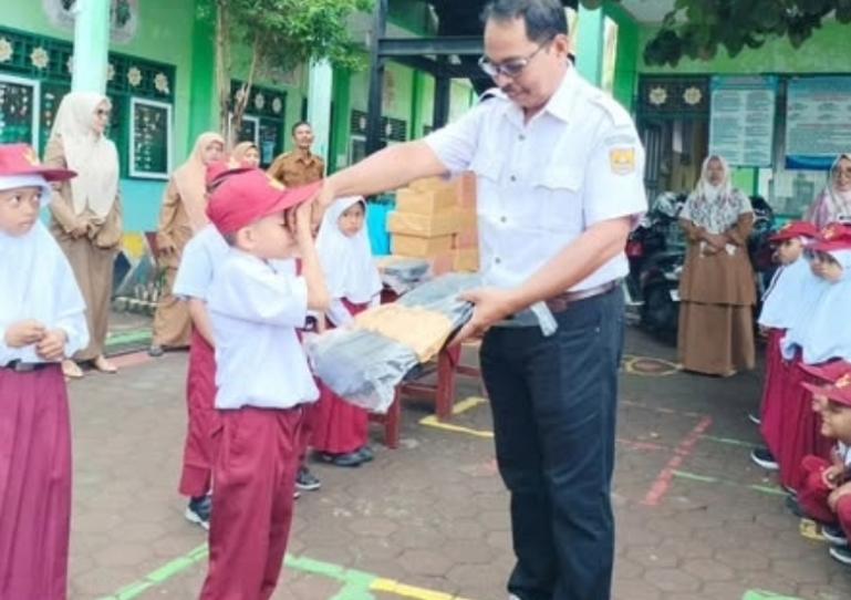 Kepala Desa Ampalu, Kota Pariaman, Masrutin serahkan penghargaan kepada salah satu murid SDN 15 Ampalu yang berprestasi, Senin pagi (21/7/2025). IST