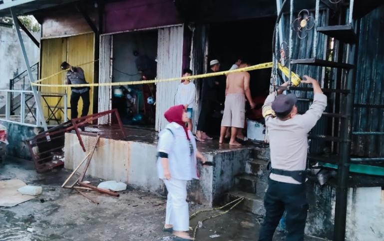 Pihak kepolisian memasang garis polisi di bekas bangunan Lapau Panjang di Kawasan Danau Cimpago, Padang, Minggu (20/7/2025). IST