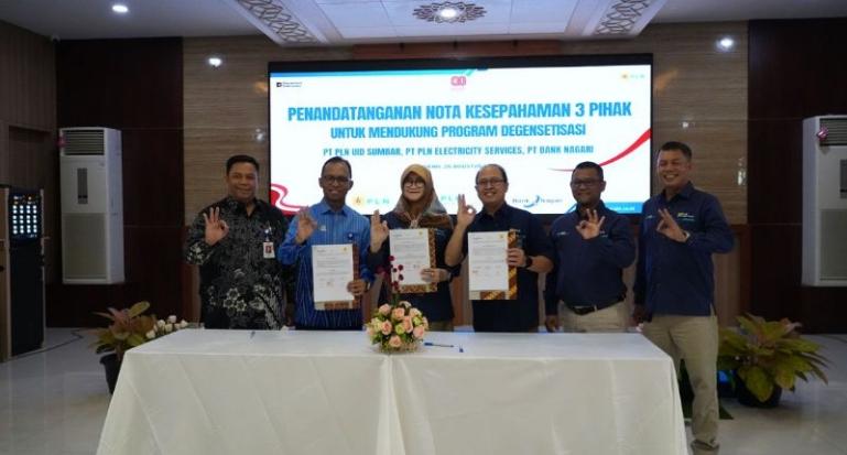 Direktur Keuangan Bank Nagari Roni Edrian, General Manager PLN PLN UID Sumbar Ajrun Karim, danDirektur Utama PT PLN Electricity Services Susiana Mutia menunjukkan nota kesepahaman yang baru saja ditandatangani dalam perogram degensetisasi. IST