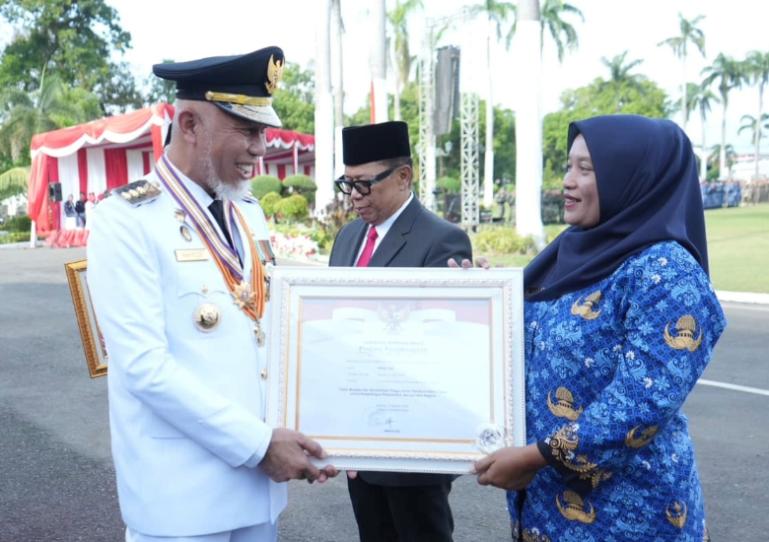 Bidan Dona Lubis saat menerima penghargaan dari Gubernur Sumbar, Mahyeldi Ansharullah, di Padang, Minggu (17/8/2025). IST