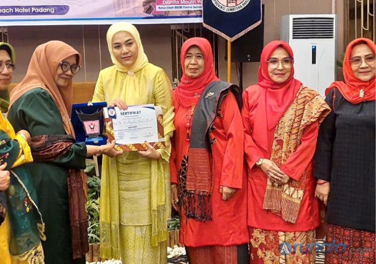 Ketua BKOW Sumbar, Dianita Maulin Vasko serahkan sertifikat sebagai narasumber dalam seminar yang diadakan organisasi ini di Padang, Jumat (10/10/2025). (dok : arunala.com