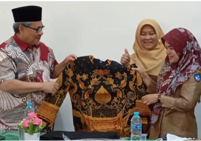 Terlihat Ketua DPRD Sumbar, Muhidi menyerahkan baju batik kepada salah satu Kepala SLTA di Kota Padang,  Senin (13/10/2025). IST