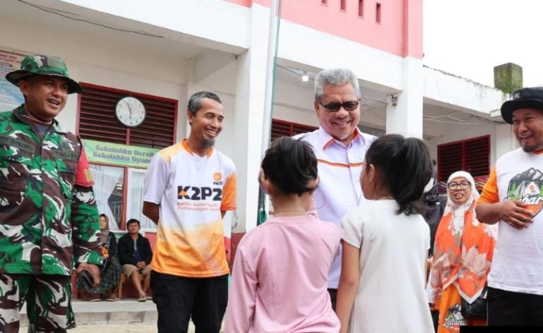 Ketua DPRD Sumbar Muhidi saat serahkan bantuan kepada sarapan pagi dan paket sembako kepada murid SD posko pengungsian korban banjir bandang di SDN 02 Cupak Tangah, Minggu (30/11/2025). IST