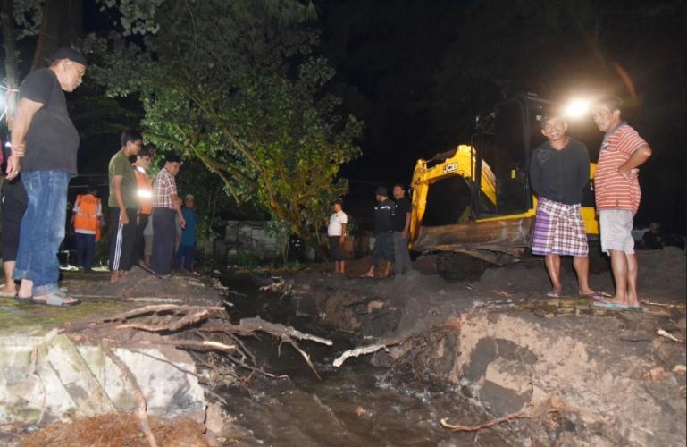 Terlihat satu unit alat berat membuat parit dengan cara mengeruk jalan untuk mengaliri banjir yang genangi rumah warga di Kelurahan Lohong, Kecamatan Pariaman Tengah, Jumat malam (28/11/2025). IST
