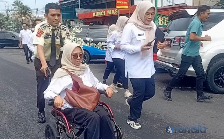 Pegawai DPMPTSP Kota Padang memakan kursi roda dibantu evakuasi saat simulasi tsunami, Rabu (5/11/2025). (dok : arunala.com)