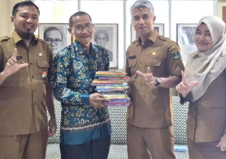 Pimpinan Pustaka Artaz Armaidi Tanjung serahkan 18 judul buku kepada Dinas Kearsipan dan Perpustakaan Sumbar, Selasa (11/11/2025). IST