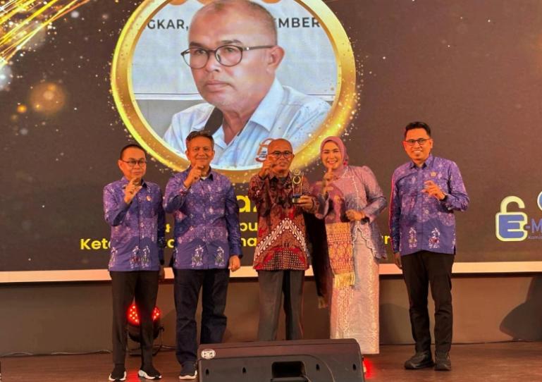 Terlihat ketua PJKIP Sumbar, Almudazir saat menerima penghargaan Achievement Motivation Person 2025 dari KI Sumbar, Selasa (18/11/2025) malam. IST