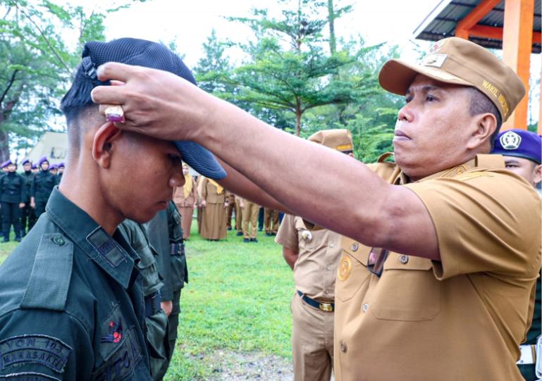 Wawako Pariaman, Mulyadi memasangkan topi pada salah seorang peserta tanda dimulaikan Pradiksar Menwa Pagaruyung Sumbar 2025 Angkatan XLVIII di Pantai Kata, Kota Pariaman,  Selasa (18/11/2025). IST