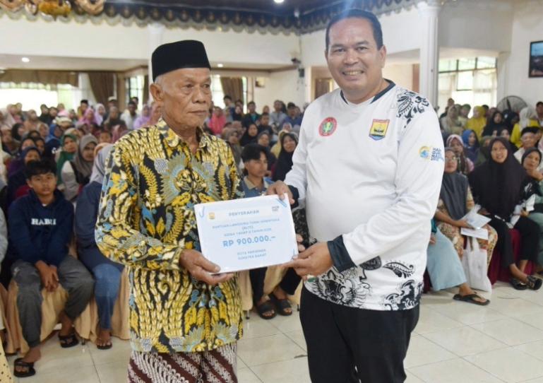 Wali Kota Yota Balad serahkan bantuan BLTS Kesra kepada salah seorang penerima manfaat di Balairung Rumah Dinas Wali Kota Pariaman, Sabtu (22/11/2025). IST