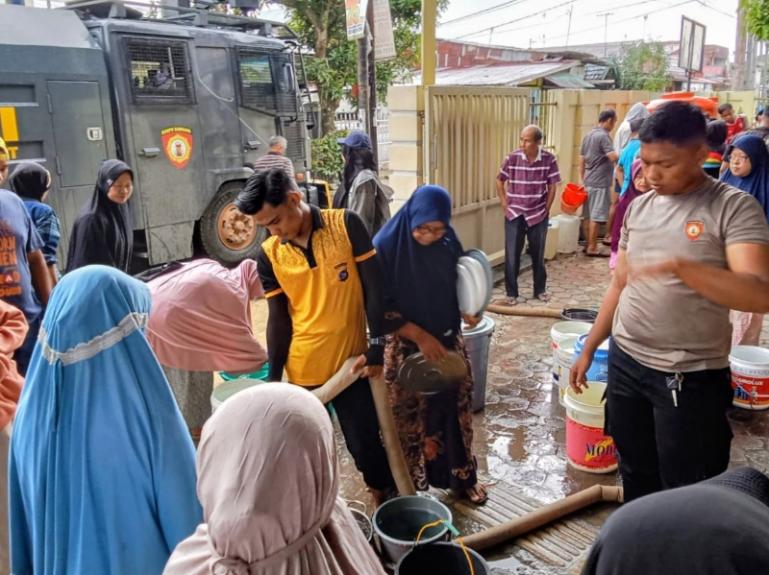 Terlihat personel kepolisian dari Dit Samapta Polda Sumbar distribusikan air bersih kepada warga di Masjid Almunawarah Siteba menggunakan kendaraan taktis AWC (Armoured Water Cannon), Minggu (7/12/2025). IST