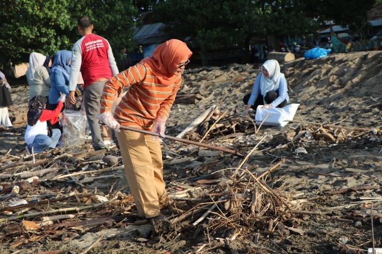 Kadis DKP Sumbar Dr. Ir. Reti Wafda, MTp bersama jajaran melakukan aksi gotong royong membersihkan kawasan pantai akibat material sampah yang terbawa arus pascabencana banjir bandang. IST