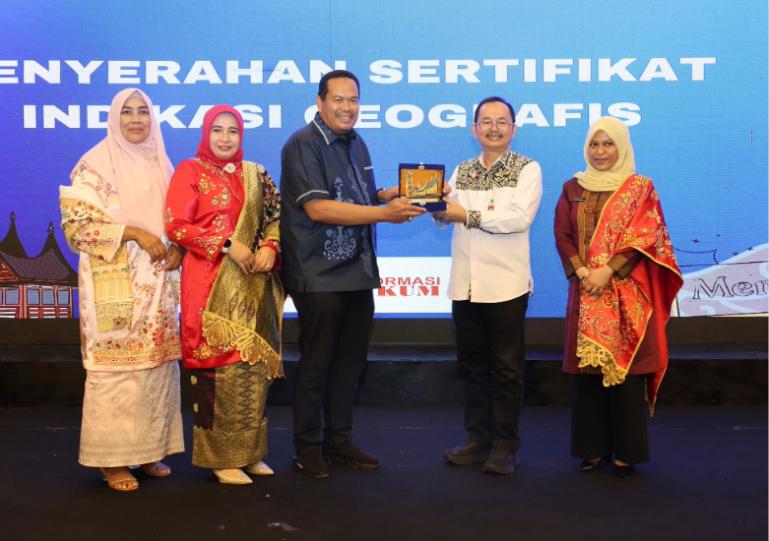 Wali Kota Pariaman, Yota Balad didampingi Ketua Dekranasda Kota Pariaman, Yosneli Balad saat menerima Sertifikat IG untuk produk unggulan Sulaman Kapalo Panitik Nareh dari Kanwil Kemenkum Sumbar di Padang, Jumat (5/12/2025). IST