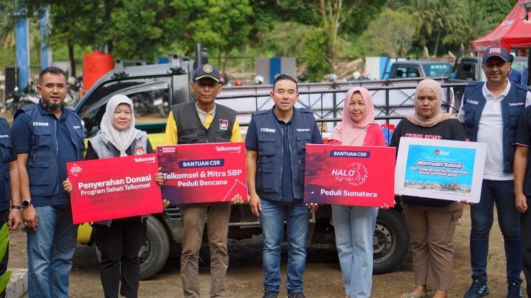 Vice President Consumer Business Area Sumatera Telkomsel, Saki Hamsat Bramono bersama korban terdampak bencana saat penyeraham bantuan CSR. IST