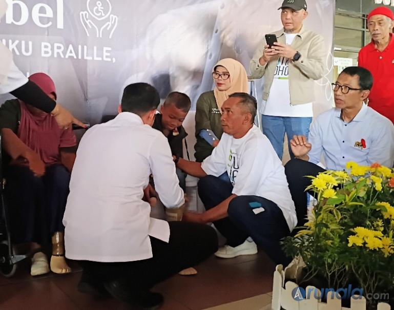 GM API BIM, Dony Subardono bersama perwakilan dari Kick Andy Foundation Ali Sadini dan Wabup Padangpariaman, Rahmat Hidayat memasangkan kaki palsu kepada salah seorang penyandang difabel, Jumat (23/1/2026). (dok : arunala.com)