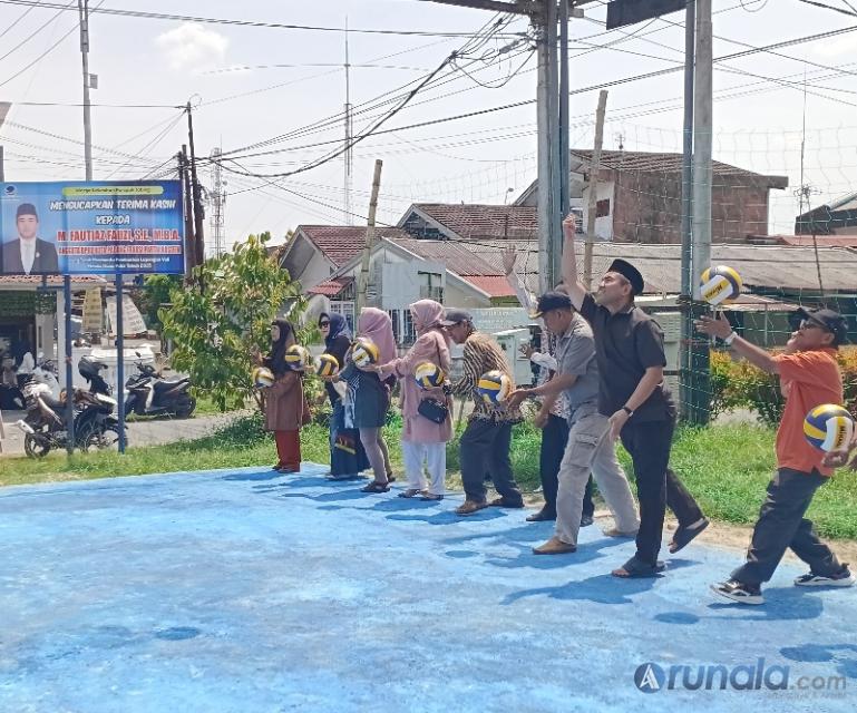 Anggota DPRD Kota Padang, Fautiaz Fauzi bersama Lurah Parupuk Tabing, tokoh masyarakat Parupuk Tabing lakukan servis pertama saat resmikan lapang voli baru di tempat tersebut, Sabtu siang (24/1/2026). (dok : arunala.com)