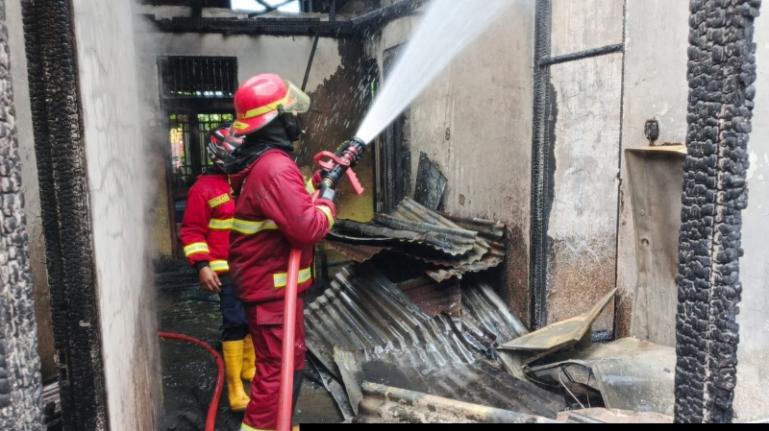 Terlihat petugas Damkar Padang memadamkan api yang terdapat pada sisa-sisa bangunan yang terbakar di kawasan Jati, Kota Padang, Senin siang (26/1/2026). IST