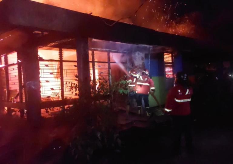 Petugas Damkar Kota Padang berjibaku memadamkan api yang membakar dua rumah warga  Jalan Pulai Kampung Pinang Kelurahan Jati, Padang Timur, Senin malam (12/1/2026). IST