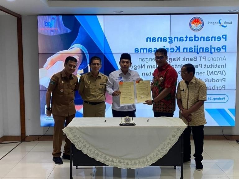 Direktur Utama Bank Nagari Gusti Candra bersama Direktur IPDN Kampus Sumbar Lalu Satria Utama memperlihatkan nota kesepahaman, Selasa (24/2/2026). IST