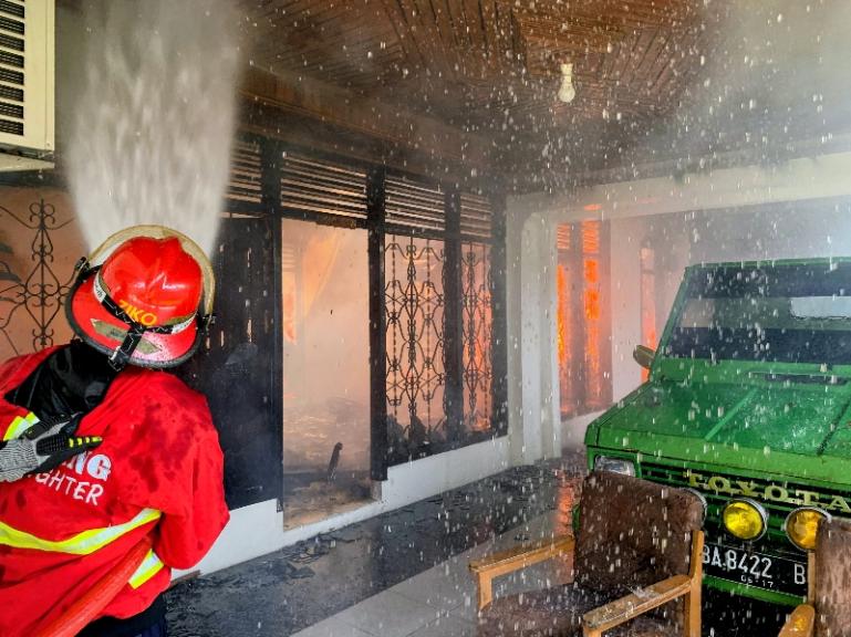 Petugas Damkar Padang sedang memadamkan api yang membakar salah satu rumah di Kalumbuk, Kuranji, Sabtu (21/2/2026) siang. IST