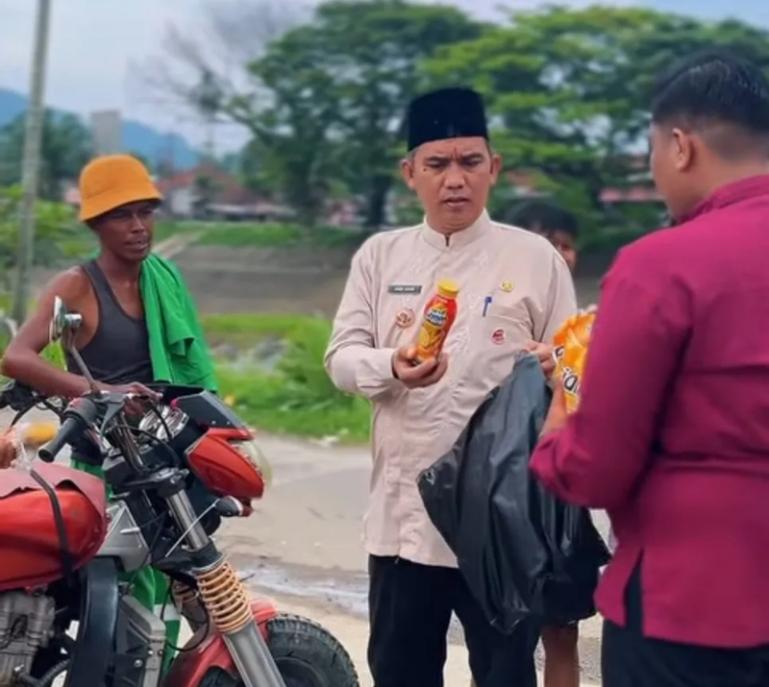 Camat Lubeg, Andi Amir membagikan minuman kemasan kepada beberapa petugas LPS yang ada di di kawasan Simpang Batung Taba dan TPS Lubeg, Jumat siang (27/3/2026). IST