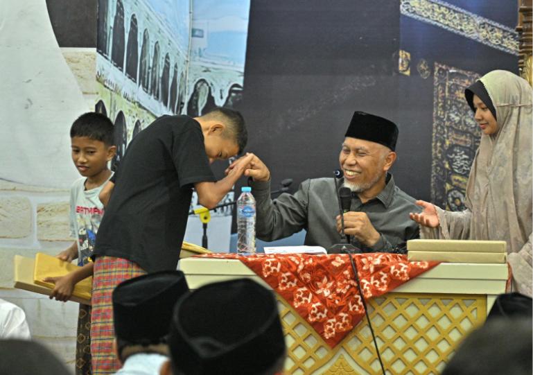 Gubernur Sumbar Mahyeldi serahkan Al Quran kepada siswa saat Safari Ramadan di Masjid Raya Limau Manis, Kecamatan Pauh, Kota Padang, Jumat malam (7/3/2026). IST