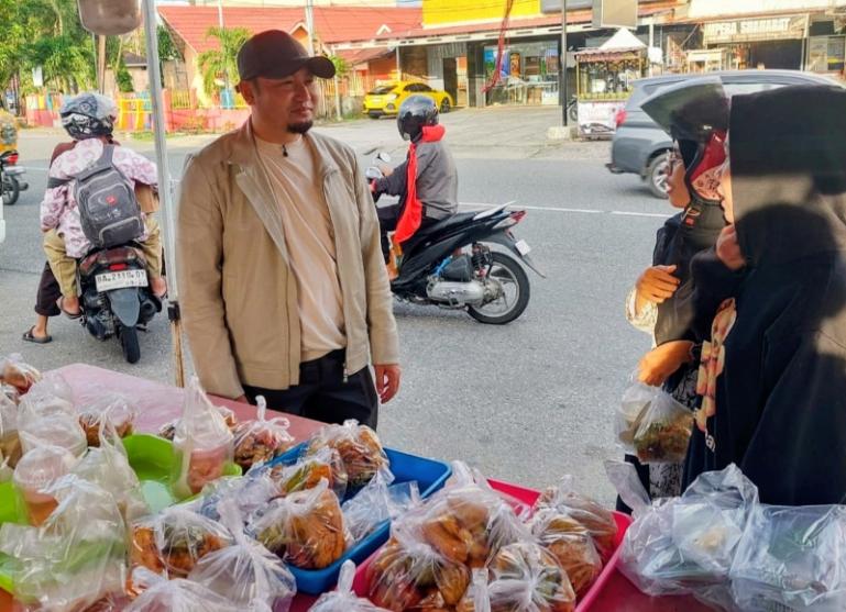 Anggota Komisi IV DPR RI, Rahmat Saleh bersama warga ditengah kegiatan pemberian takjil pada masyarakat di salah satu lokasi di Padang, kemarin. IST