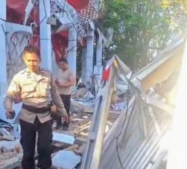 Petugas kepolisian memeriksa puing-puing bangunan yang runtuh akibat gempa di tenggara Bitung, Provinsi Sulawesi Utara, pada Kamis pagi (2/4/2026) pukul 05.48 WIB. IST