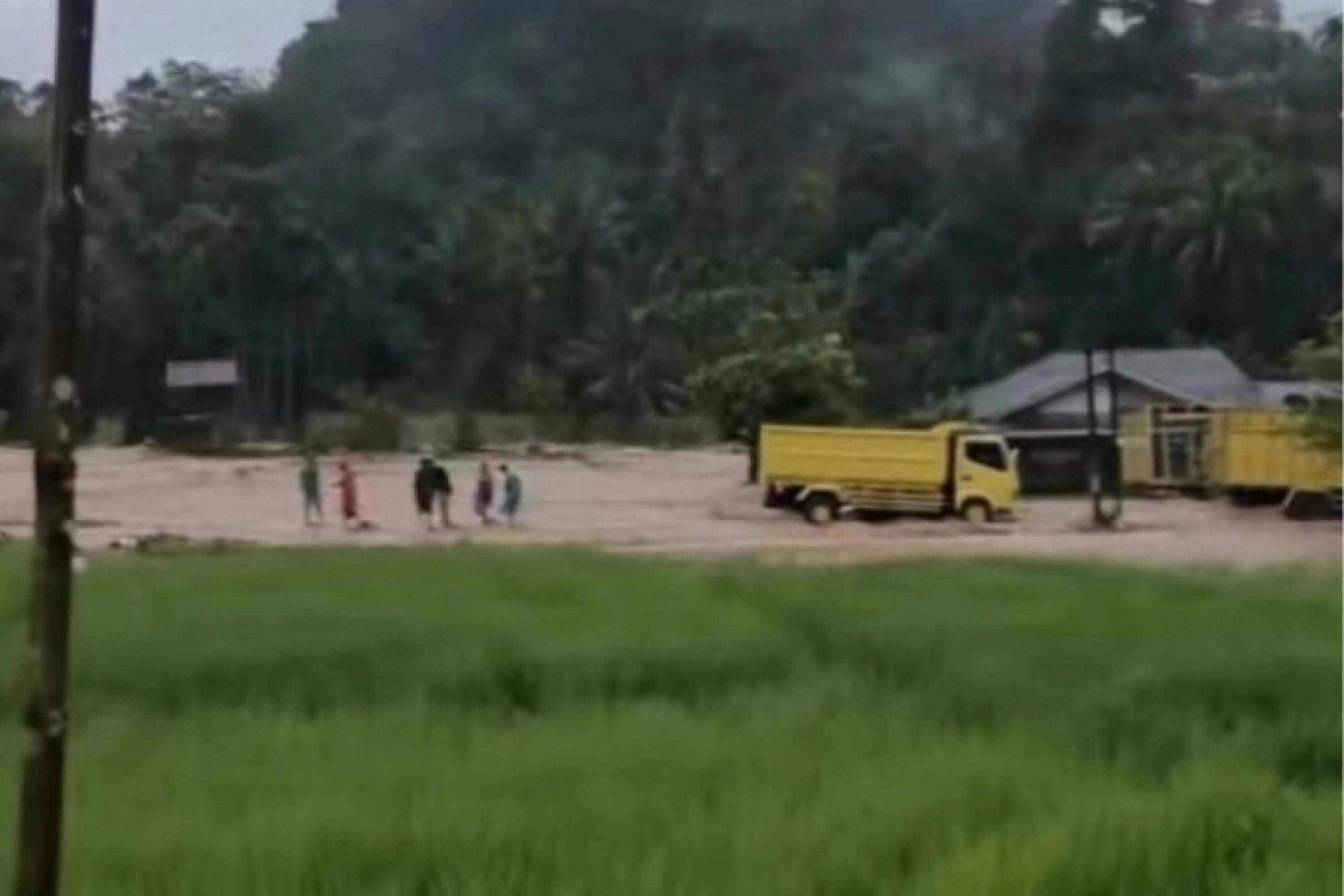 Dua kendaraan dan beberapa warga terjebak banjir yang melanda di Nagari Alahan Mati, Kecamatan Simpang Alahan Mati, Kabupaten Pasaman, Selasa siang (14/4/2026). IST