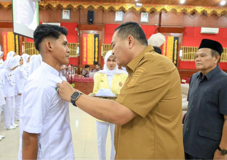 Wali Kota Yota Balad secara simbolis pasangkan uniform pada salah seorang mahasiswa STIKes Piala Sakti Pariaman saat acara capping day, Selasa (5/5/2026). IST