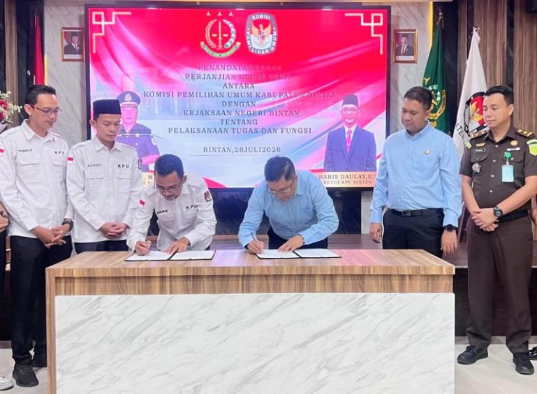 Kajari Bintan, Rusmin SH MH dan Ketua KPU Kabupaten Bintan, Haris Daulay, tanda tangani naskah kerja sama disaksikan oleh staf dari masing-masing instansi, Selasa (28/7/2026). IST