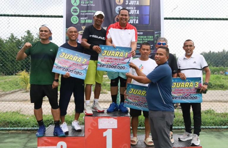 Wakil Wali Kota Pariaman Mulyadi serahkan hadiah pertama juara Ganda Putra kepada Wali Kota Yota Balad dan Pudin diTurnamen Tenis KU 110 Tahun, Minggu sore (19/7/2026). IST