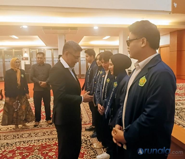 Ketum DPP Alumni UBH, Mardiansyah serahkan tanda pengenal KKN kepada perwakilan mahahasis disaksikan Rektor Prof. Dr. Diana Kartika, di Padang, Jumat (31/7/2026). (dok: arunala.com)