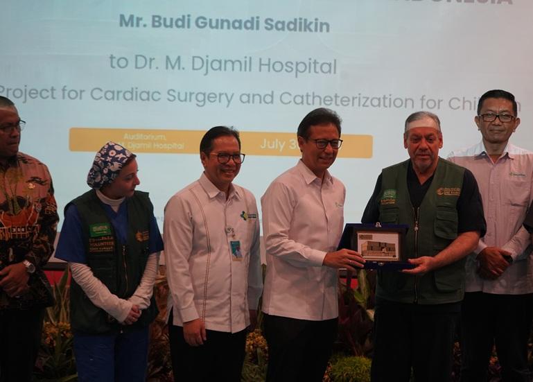 Menteri Kesehatan RI Budi Gunadi Sadikin menyerahkan plakat kepada Tim KSRelief Prof. Zohair Al-Halees saat penutupan rangkaian Bakti Sosial dan Alih Teknologi Kardiovaskular di RS M. Djamil, Kamis (30/7/2026), yang berlangsung di Auditorium Lantai 4 Gedung Administrasi dan Instalasi Rawat Jalan. HUMAS RS M. DJAMIL